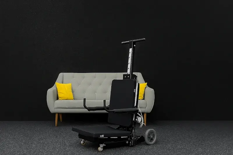 Foldable electric stairlift chair in front of a sofa, ideal for moving seniors on stairs