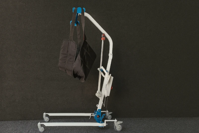 Side view of an electric patient lift with black sling – suitable for moving elderly and low-mobility users at home or in care centers