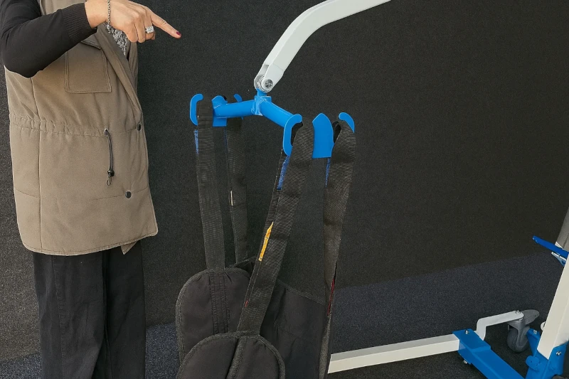 Close-up view of sling hooks on a patient lift, showing safe attachment points for easy and secure patient transfers