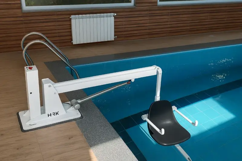Pool lift with safe swiveling seat installed at an indoor pool for seniors or people with disabilities