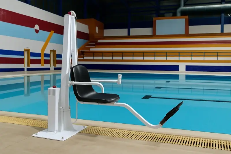 Pool lift with safe seat at an indoor sports complex; accessibility for people with limited mobility